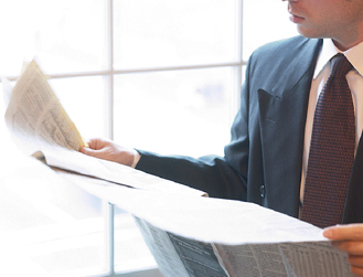 caucasian-businessman-reading-newspaper-beside-window.jpg